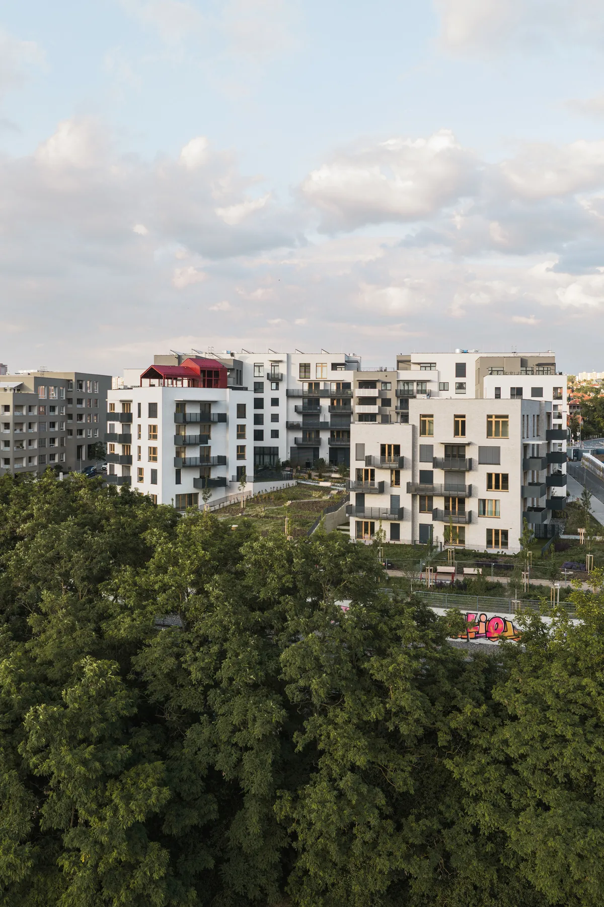 Bytový dům C v Modřanském cukrovaru: štítek A, lofty a recyklace šedé vody 4 Pohled na rezidenční soubor Modřanský cukrovar přes koruny stromů