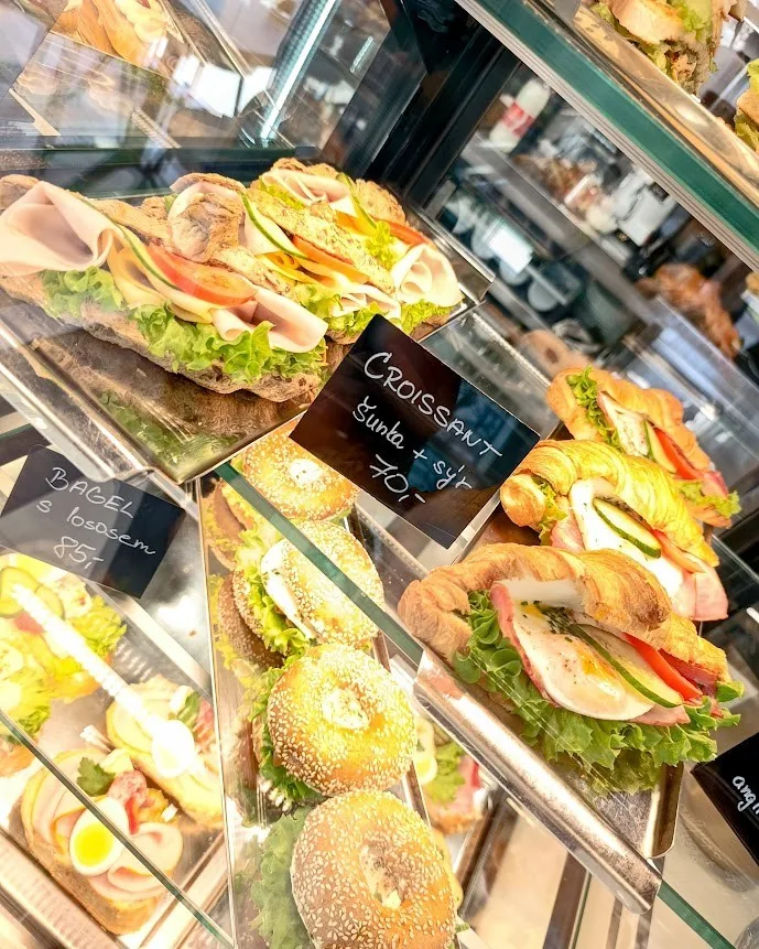 Earnest v Kroměříži: kavárna, restaurace a bowling v Domě kultury 4 Chlazená vitrína s bagetami, croissanty a bagely, u nich cedulky s cenami