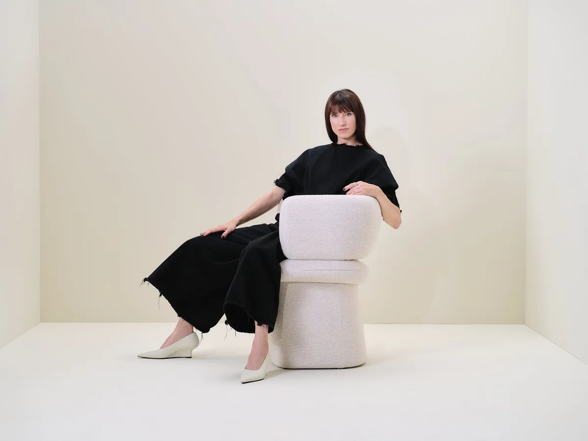 Z jednoho křesla celá kolekce: Lucie Koldová navrhla pro LD Seating sezení Dafna 9 Žena v černém sedí v bílém křesle Dafna s čalouněnou podnoží